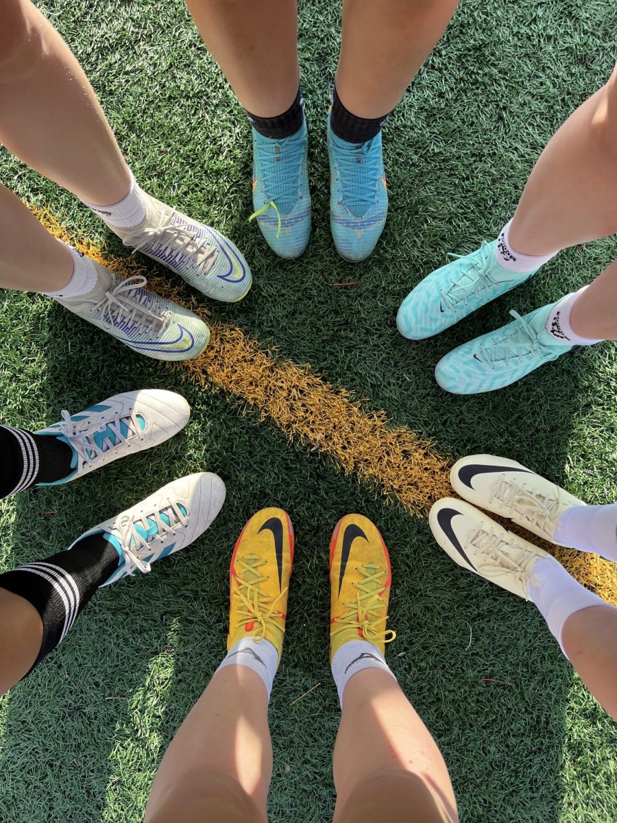 Members of the Rocky girls soccer team show off colorful array of cleats.